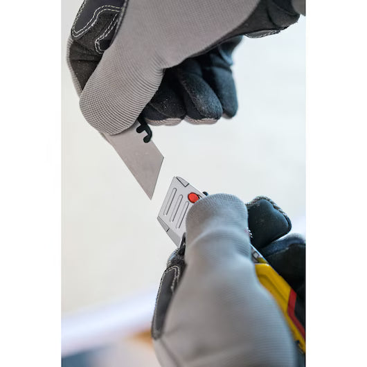 Person wearing gloves using a knife with a visible blade and handle. STANLEY® FATMAX® Retractable Folding Utility Knife