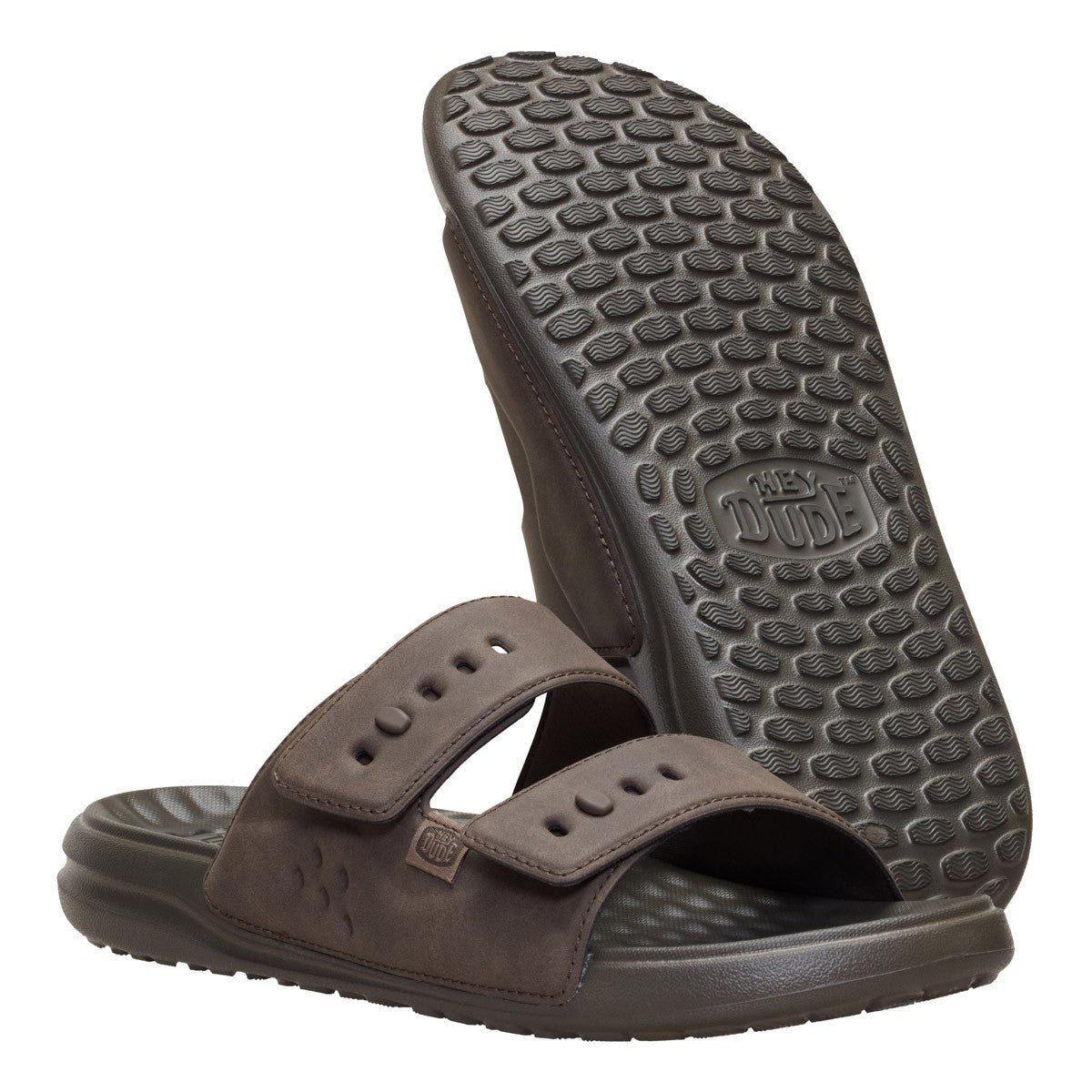 A pair of dark brown slide sandals shown on a white background, with one sandal standing upright to display the textured outsole and the other lying flat to show the top strap design.