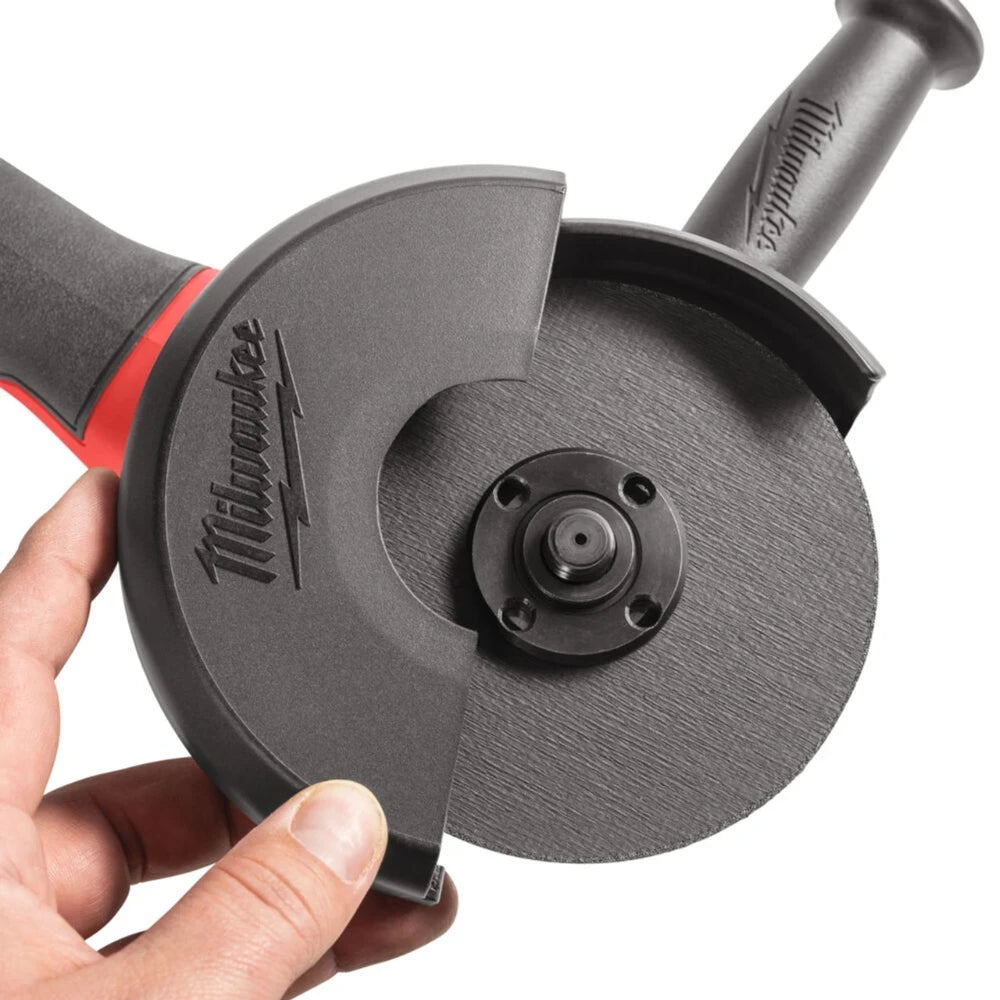 Hand holding a Milwaukee tool with a circular disc attachment on a white background