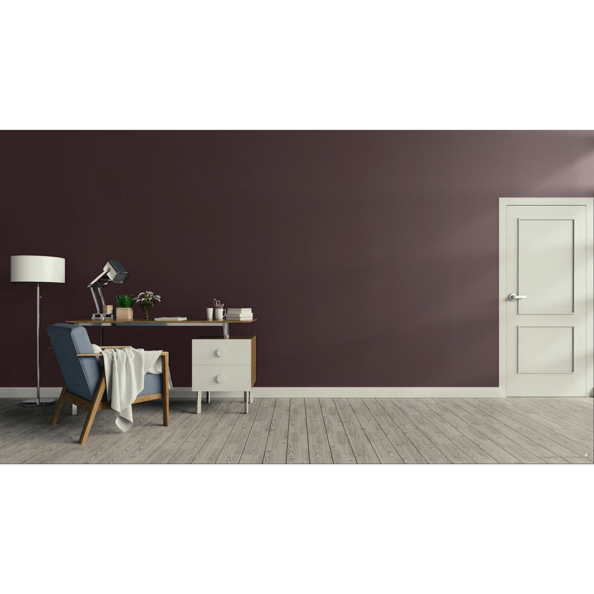 A modern interior room with a dark plum-brown accent wall, light wood flooring, a white door on the right, and a home office setup on the left featuring a desk, lamp, chair, and throw blanket.