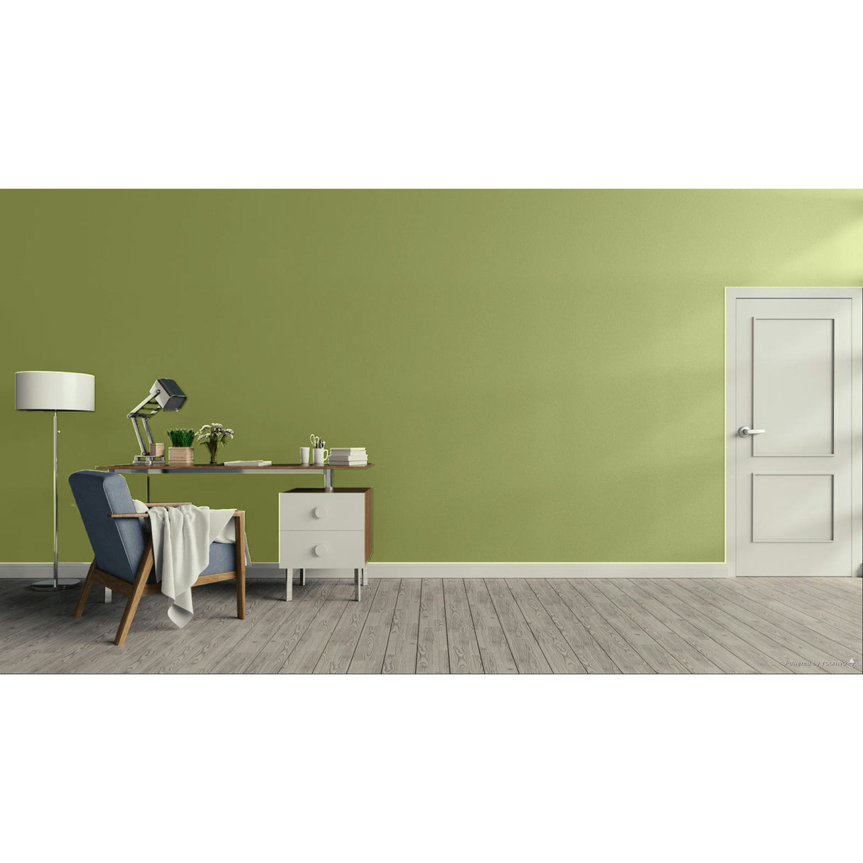 A styled interior room with a sage green wall, gray wood floor, a white door on the right, and a home office setup on the left featuring a blue armchair, desk, lamp, and small cabinet.