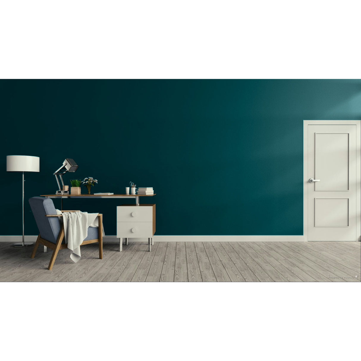 A modern interior scene with a deep teal wall, light wood floor, a white door on the right, and a home office setup on the left featuring a desk, lamp, chair, and draped throw blanket.