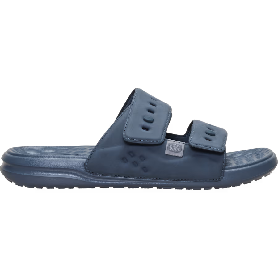 A single blue slide sandal with a molded sole and two adjustable hook-and-loop straps, shown in profile against a plain white background.