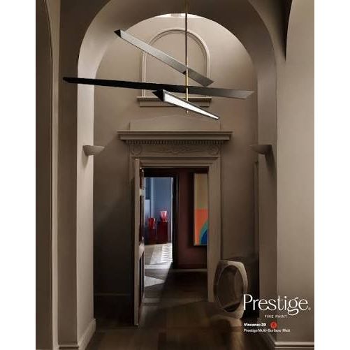 A modern multi-light linear chandelier with three intersecting angled arms, shown hanging in a grand arched hallway. The fixture features a brushed silver metal finish on the upper arms and a black finish on the lower bar, with a warm white light glowing from the central bulb.
Prestige Vincenzo Paint