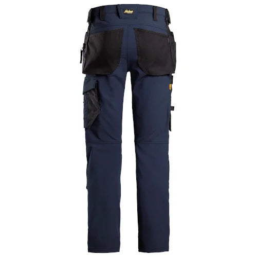 A pair of navy blue work pants with black utility pockets and a waist belt, shown from the back on a white background. Snickers 6271 AllroundWork Full Stretch Trousers Holster Pockets