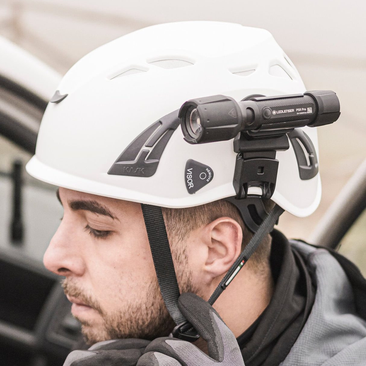 Person wearing a white helmet with a mounted light device inside a vehicle.