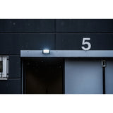 Building facade with number 5 and a light fixture on a snowy day Brennenstuhl JARO 4060 LED Spotlight 30W | 3450 Lumen | IP65 Outdoor LED Floodlight