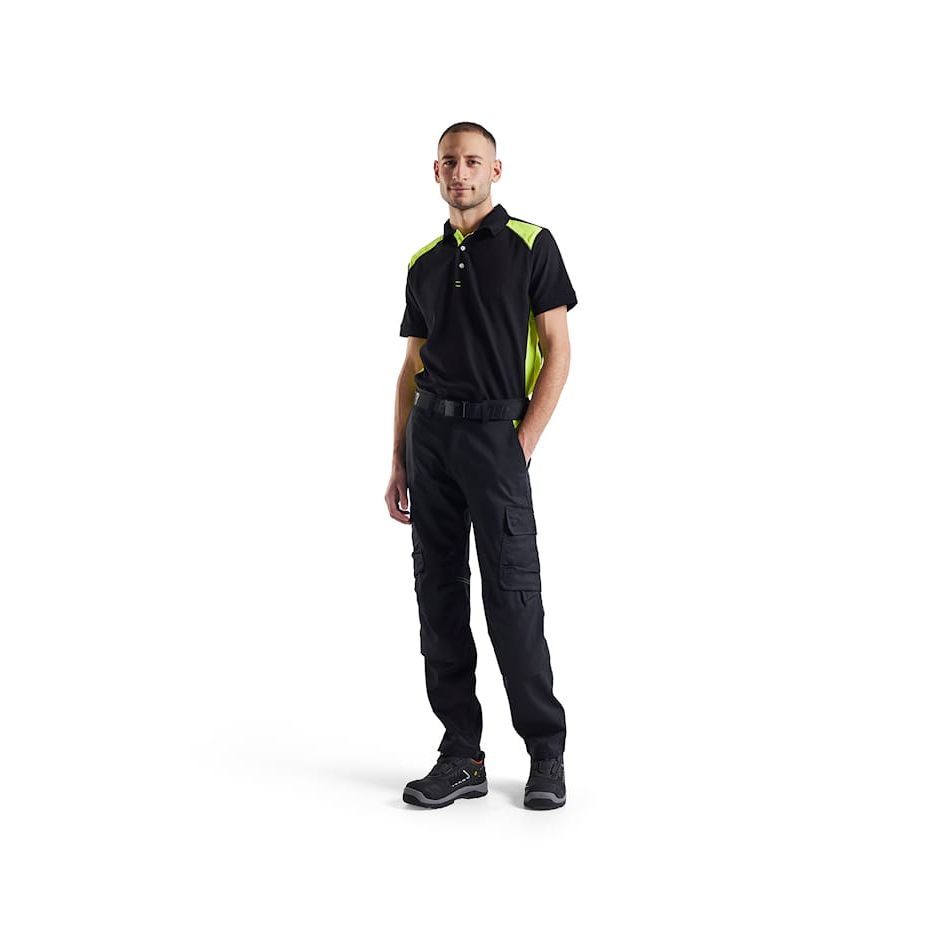 Man wearing a black and yellow work uniform on a white background