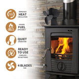 A black wood-burning stove with a visible fire inside, shown next to a white text panel listing features such as improved heat circulation, higher fuel efficiency, quiet operation, cordless ready-to-use batteries, and a 4-blade fan. The stove is set against a light stone wall, and a black fan is mounted above it. De Vielle Heritage 4 Blade Stove Fan
