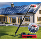 A solar-powered roof cleaning brush with an extendable black pole and red bristles is shown on a green lawn in front of a house with solar panels. A circular inset shows the brush in action on the solar panels, and the main product is displayed on the grass with its hose attached.