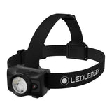 An LEDLENSER headlamp with a dark green and black camouflage-patterned head strap, featuring a dark green lamp housing with three clear LED lenses, shown on a solid white background. Ledlenser Headlamp HF6R | 900 Lumen