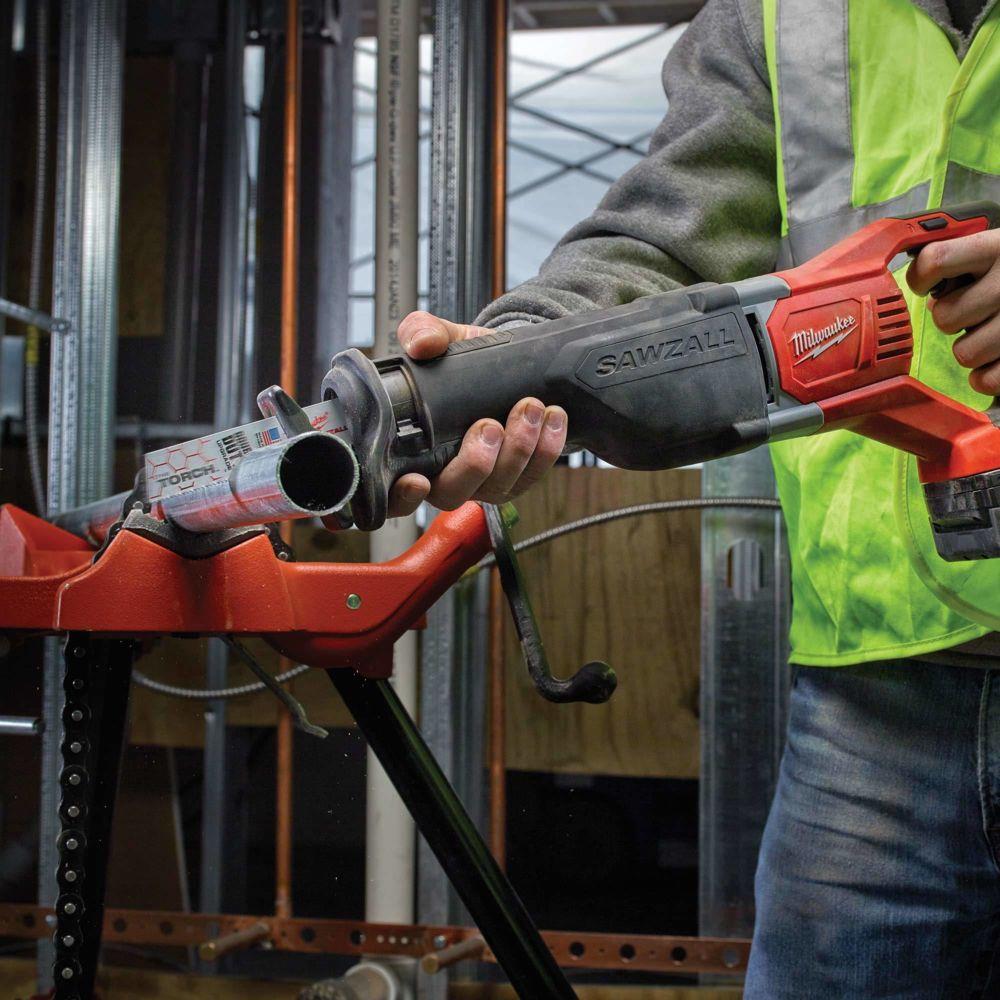 Person using a Milwaukee Sawzall tool in a construction setting