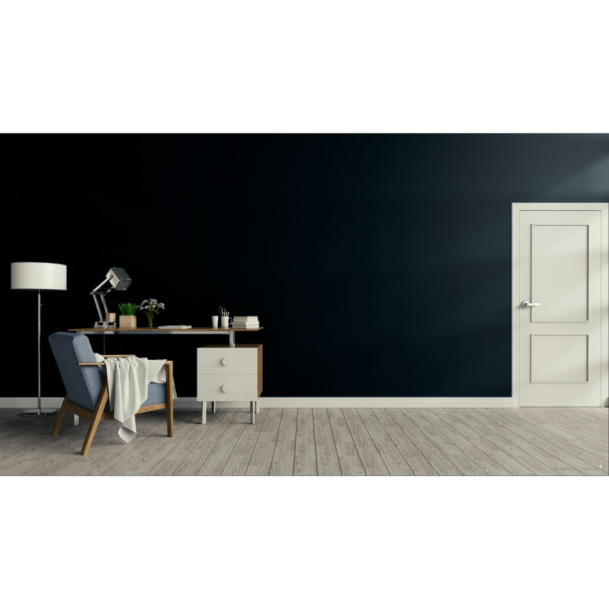 A modern room scene with a dark navy wall, light wood floor, a white door on the right, and a home office setup on the left featuring a desk, lamp, chair, and draped throw blanket.