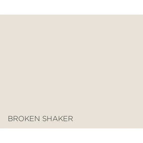 A flat warm light beige color block with the text 'BROKEN SHAKER' printed in dark gray at the bottom left.