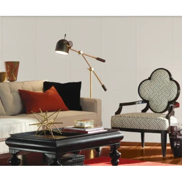 Living room with a beige sofa, patterned armchair, and decorative lamp. Prestige Coco Light