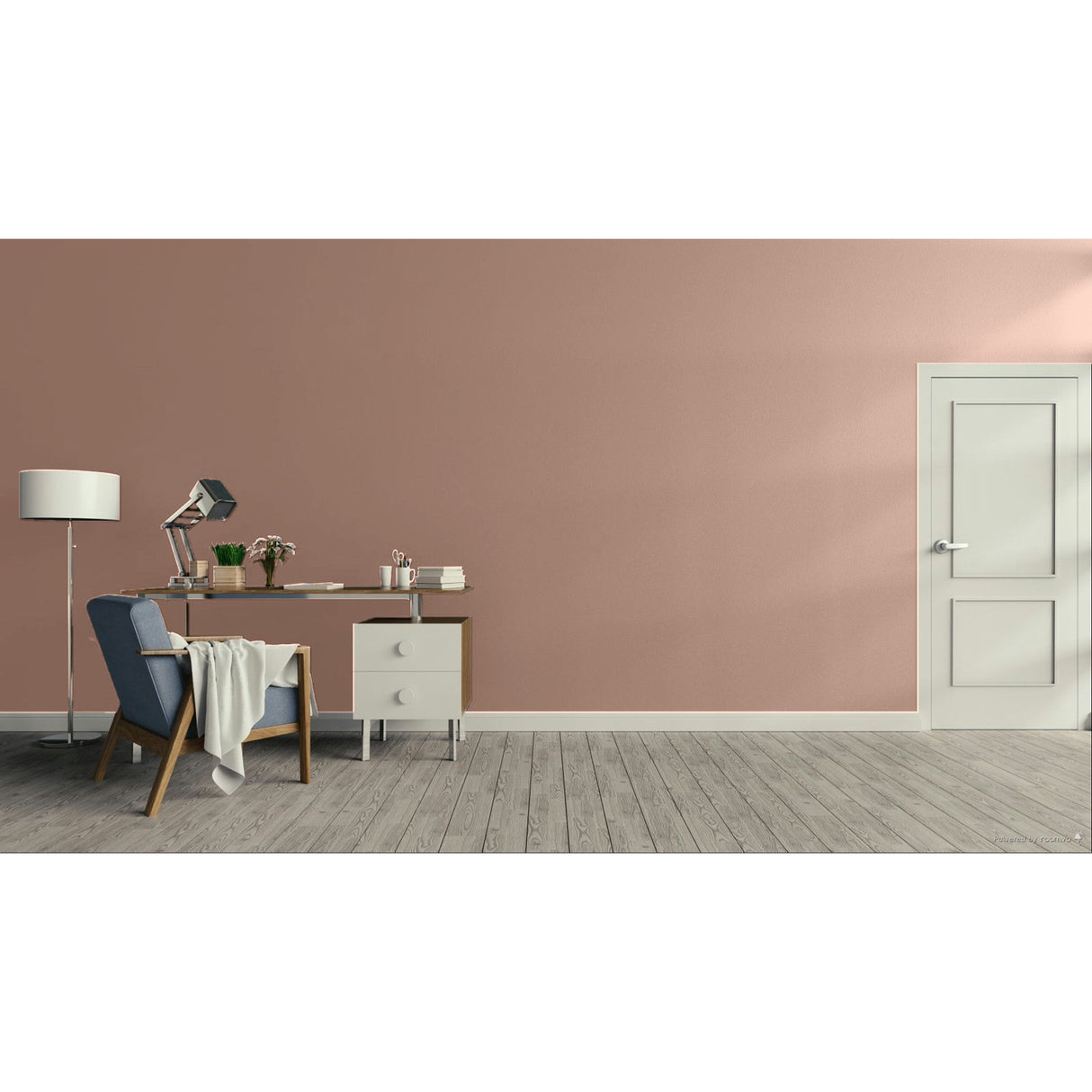 A minimalist room scene with a dusty pink wall, light gray wood floor, a white door on the right, and a home office setup on the left featuring a desk, lamp, chair, and throw blanket.