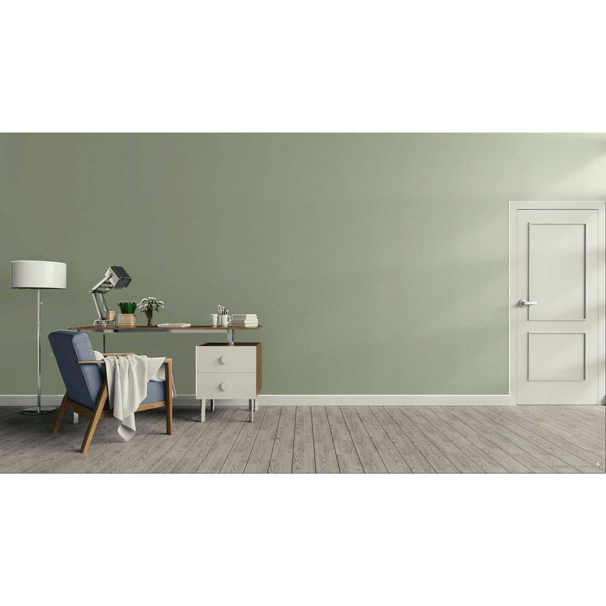 A minimalist room scene with a sage green wall, light wood floor, a white door on the right, and a home office setup on the left featuring a desk, lamp, chair, and throw blanket.