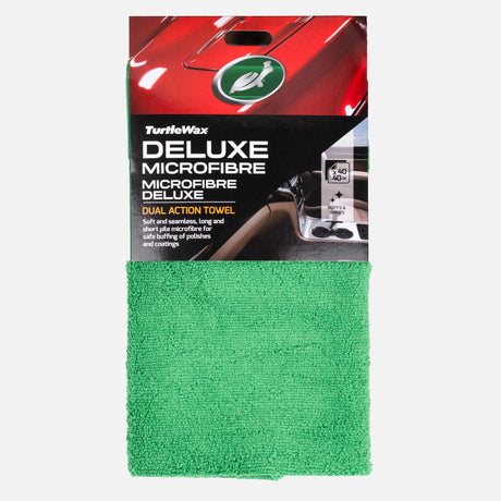 A green microfiber car towel from TurtleWax, packaged in its original retail card sleeve. The packaging features a red car graphic at the top and product details in white and gold text. Turtle Wax Deluxe Microfibre Dual Action Towel