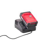 A red and black Milwaukee battery charger with a red and black battery pack resting on top, shown on a white background with a black power cord extending to the lower left. Einhell 18V Combi Drill with 2 x 2Ah Li-Ion Batteries