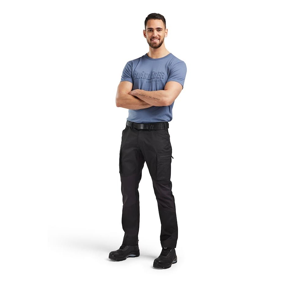 Man wearing a blue T-shirt and black pants on a white background. Blaklader 1459 Service Trousers Stretch