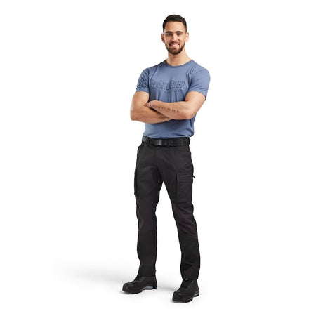Man wearing a blue T-shirt and black pants on a white background. Blaklader 1459 Service Trousers Stretch