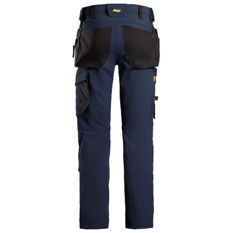 A pair of navy blue work pants with black utility pockets and a waist belt, shown from the back on a white background. Snickers 6271 AllroundWork Full Stretch Trousers Holster Pockets