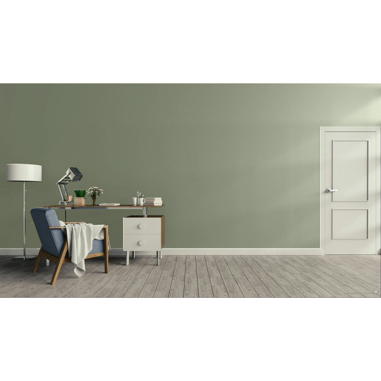 A minimalist room scene with a sage green wall, light wood floor, a white door on the right, and a home office setup on the left featuring a desk, lamp, chair, and throw blanket.