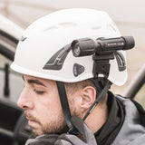 Person wearing a white helmet with a mounted light device inside a vehicle.